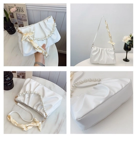 Detail view of white ruched cloud bag featuring pearl handle and silk ribbon accents