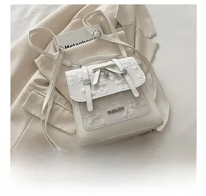 Detail view of the mini handbag with lace patchwork and elegant heart pendant