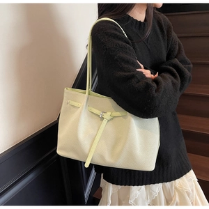 Vue détaillée du sac seau vert pistache montrant le cuir synthétique texturé et la boucle