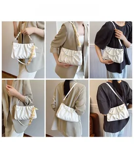 Detailed views of white pleated cloud bag with pearl handle and satin ribbon on model