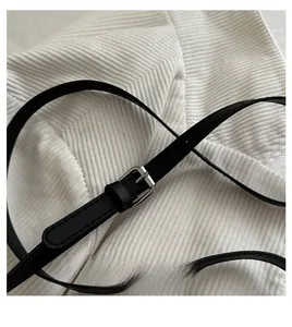 Detail of black faux leather strap with adjustable silver buckle and smooth edge finish