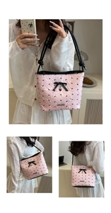 Detail of pink bucket bag featuring black bow patterns and heart-shaped metal pendant