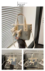 Detalle del bolso tipo cubo azul con estampado de mariposa y colgante de perrito