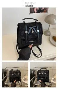 Detail of black leather backpack with floral embroidery and bow heart pendant