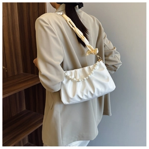 White ruched cloud bag featuring elegant pearl handle and champagne silk scarf detail