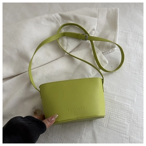 Detail view of a bright green PU leather crossbody bag with silver buckles and adjustable strap