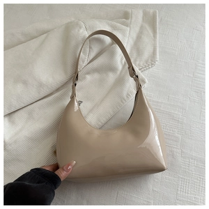 Detail of minimalist beige patent leather crescent shoulder bag with high glossy finish