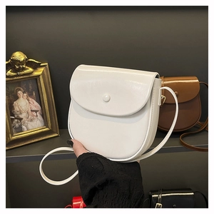 Close-up of minimalist white and brown saddle bags in smooth faux leather finish