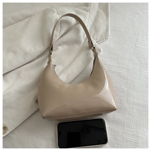Beige patent leather hobo bag with glossy finish and phone for size comparison