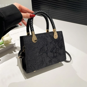 Chic black floral jacquard handbag with woven handles and luxury gold hardware