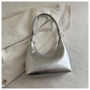 Detail of silver metallic hobo bag with high-gloss mirror finish and top zipper closure