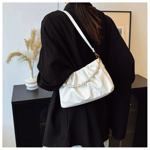 Detail of white pleated cloud bag with pearl chain strap and silk texture finish