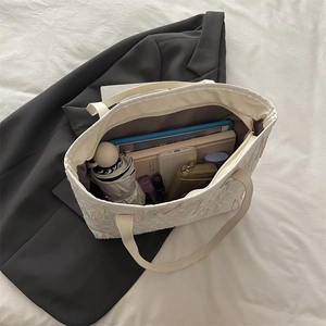 Spacious striped canvas tote bag showing interior storage for a tablet and accessories