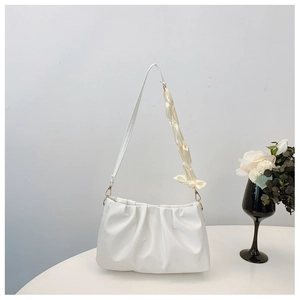 Detail of white pleated cloud bag featuring soft texture and stylish silk scarf bow knot