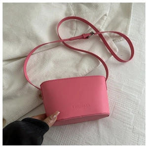 Detail of macaron pink leather crossbody bag showing FANYISSA embossed logo and adjustable strap