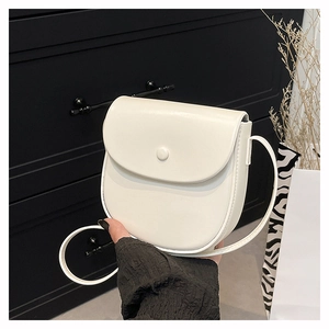 Detail of white saddle bag with magnetic flap closure and slim shoulder strap for women