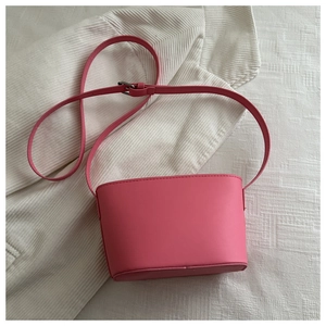 Detailed close-up of pink bucket bag made of smooth PU leather with adjustable shoulder strap