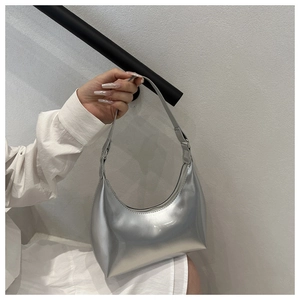Close-up of a silver mirror-finish hobo bag with a metallic crescent moon design