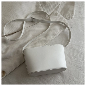 Vue détaillée du sac seau minimaliste en cuir PU blanc avec sangle réglable et boucle argentée