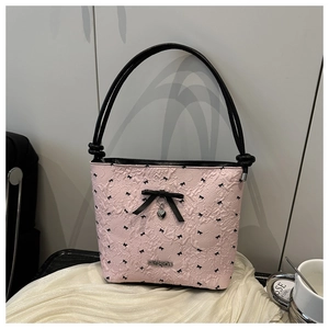 Detail of pink bubble fabric shoulder bag with black bows and heart pendant