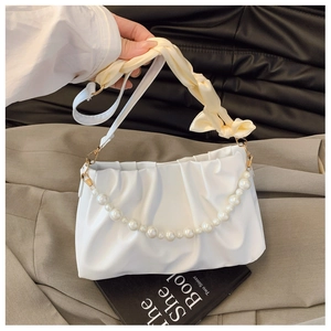 Close-up of white ruched cloud bag featuring elegant pearl chain and silk ribbon handle