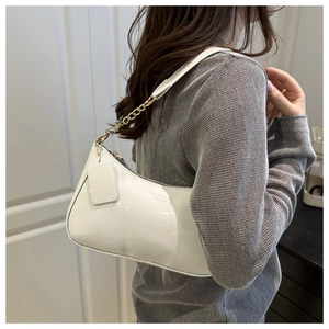 Detail of white glossy hobo bag with gold chain strap and fashion logo on leather