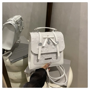 Vue détaillée du sac à dos en dentelle blanche avec nœud et pendentif en forme de cœur