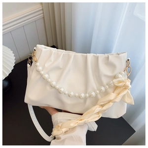 Close-up of pleated cloud bag with pearl chain and silk scarf detail in white finish