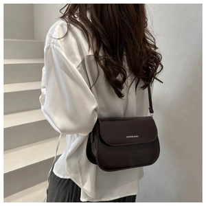 Detail of dark brown leather crossbody bag featuring Fanmissa & Bag text on matte surface