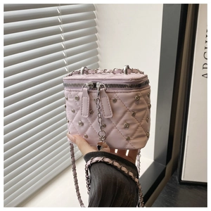 Close-up of pink quilted box bag featuring silver stud details and chain strap