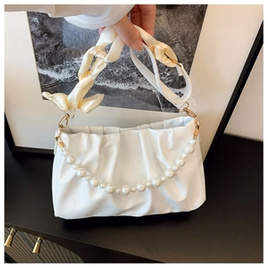 Detailed view of white pleated cloud bag with pearl chain and silk scarf handle detail
