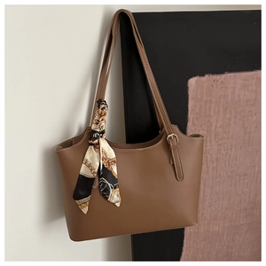 Brown leather tote bag featuring a decorative vintage print silk scarf on the handle strap