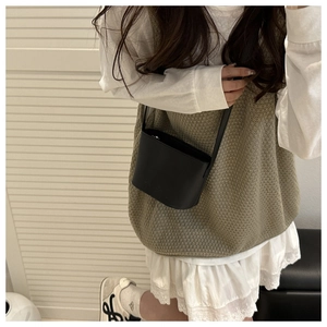 Model wearing black leather bucket cross-body bag with minimalist Korean style outfit