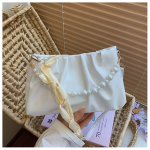 Detail of white cloud bag with pearl strap, silk scarf and gold metal hooks