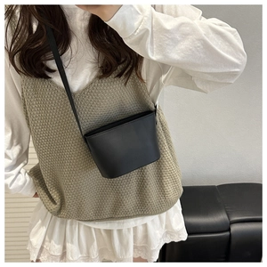 Classic black leather mini bucket bag with slim shoulder strap and minimalist embossed logo