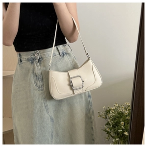Chic white leather baguette bag with silver buckle worn with casual denim skirt