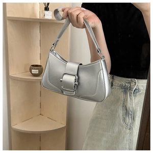 Close-up of metallic silver baguette bag featuring a large decorative square buckle