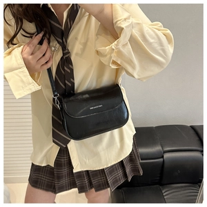 Detail of black glossy saddle bag with FANYISSA & BAG logo in academy style outfit
