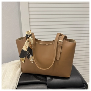 Brown faux leather tote bag detail with decorative printed scarf and metal buckle accents