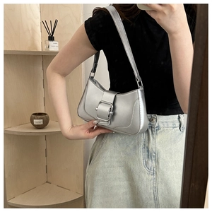 Mirror selfie showing a metallic silver underarm bag with large buckle and stitching