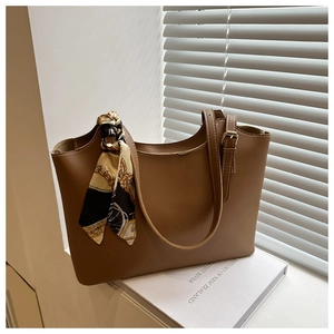Brown leather tote bag with elegant floral silk scarf detail and large capacity design