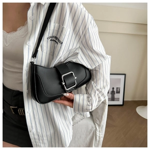 Detail of a chic black semi-circular shoulder bag with a matte finish and silver buckle