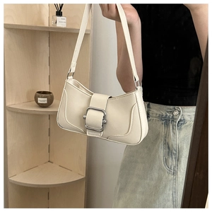 Detail of minimalist beige half-moon underarm bag with oversized silver buckle