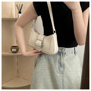 Detail of cream PU leather baguette bag with oversized silver buckle and curved stitching