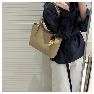 Side view of a large khaki tote bag with a silk scarf detail on a model