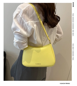 Details der hellgelben Leder-Schultertasche mit verstellbarem Riemen und Mode-Schriftzug