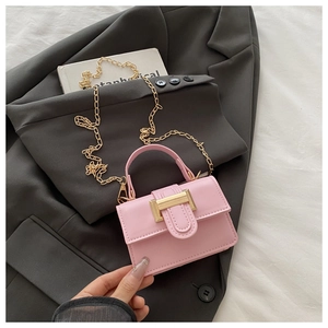 Detailed shot of pink matte leather mini bag with gold hardware on gray blazer background