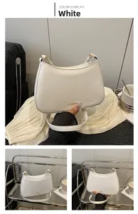 Detail der weißen Leder-Baguette-Tasche mit goldenem FASHION-Schriftzug in Halbmondform