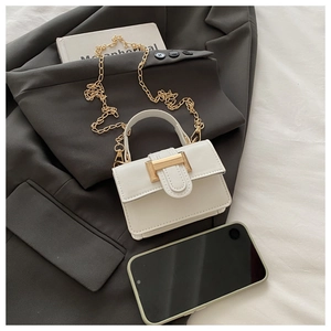Mini white leather handbag with gold metal clasp and chain strap, shown with a smartphone