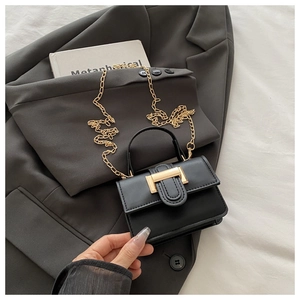 Close-up of black PU leather crossbody bag with golden chain strap and metal buckle